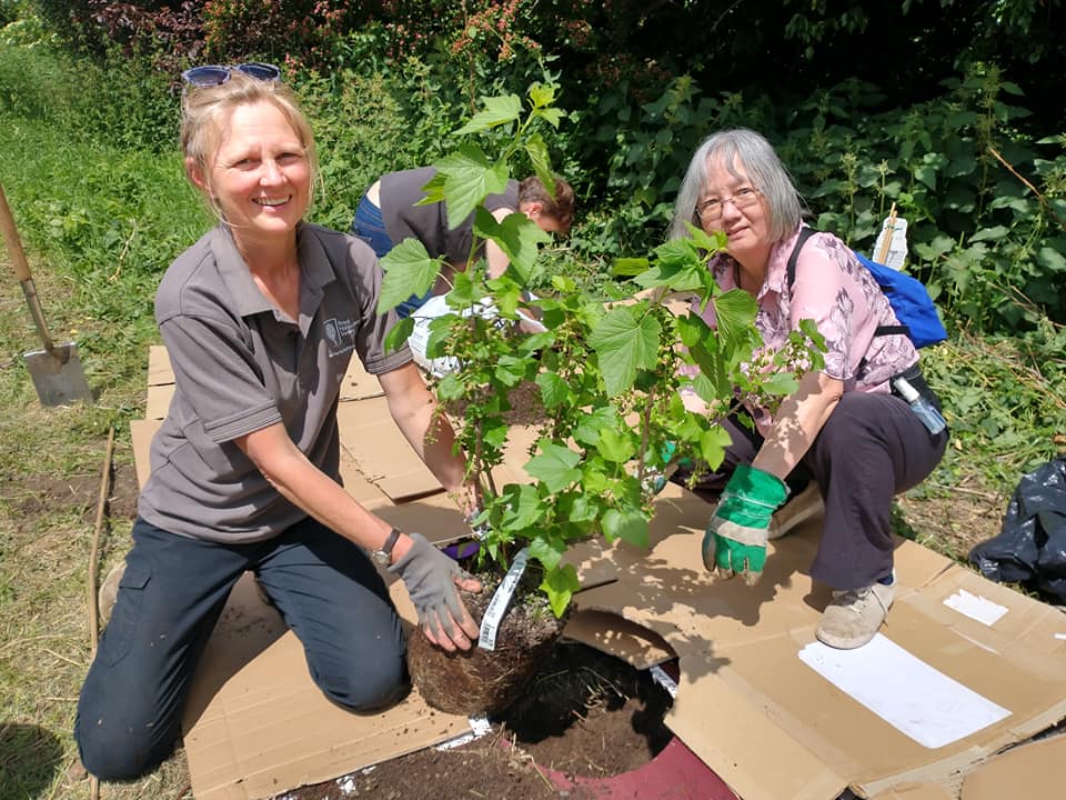 Two ladies holding a fruit bush